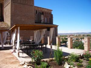 a patio with a table and chairs on a building at Complejo Rural Lifara in Aniñon