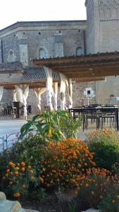 a patio with tables and flowers in front of a building at Complejo Rural Lifara in Aniñon