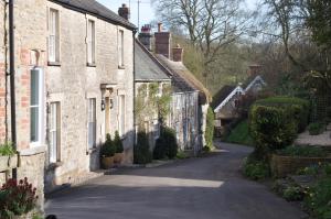 an empty street in a village with stone houses at Bittles Cottage in Dorchester