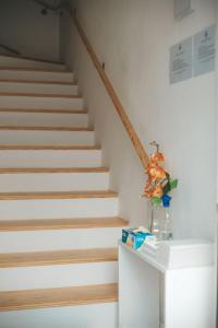 a staircase with a vase of flowers on a table at LC-House in Ponta Delgada
