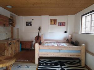 1 dormitorio con 1 cama en una habitación con guitarra en letní domek, koně, lezecká stěna, fitness, NOVĚ i možnost spaní nad hlavami koní!!!, 