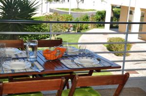 a table with plates and glasses on a balcony at SweetHome at Vila da Praia in Alvor
