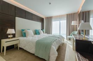 a bedroom with a large bed and a desk and a bed sidx sidx sidx sidx at Hotel Alvorada in Estoril