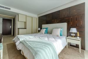 a bedroom with a large white bed and a nightstand at Hotel Alvorada in Estoril
