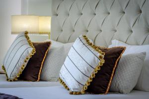 two pillows on a bed with brown and white pillows at Hotel Alvorada in Estoril
