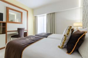a hotel room with a bed and a window at Hotel Alvorada in Estoril