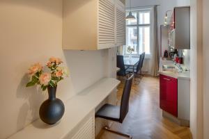 um vaso com flores sentado num balcão na cozinha em Kaprova 5 - Old Town Apartments em Praga