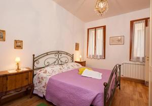 a bedroom with a purple bed and a dresser at Apostoli in Venice