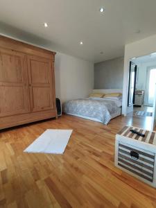 1 dormitorio con 1 cama y suelo de madera en GL Single Town Apartment, en Wiesbaden