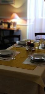 una mesa con platos y vasos encima en Cà del Vescovo, en Imperia