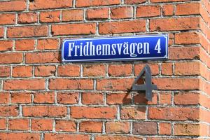 a blue street sign on a brick wall at Rörums Gårdshotell in Simrishamn