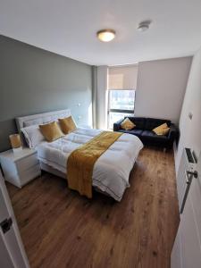 a bedroom with a large bed and a couch at Quayside Central in Liverpool