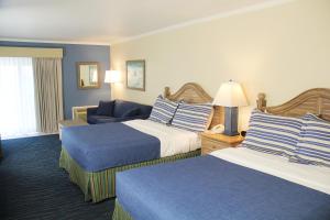 ein Hotelzimmer mit zwei Betten und einer Couch in der Unterkunft Surf Side Hotel in Nags Head