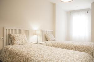 a bedroom with two beds next to a window at MalagadeVacaciones - Azuaga in Málaga