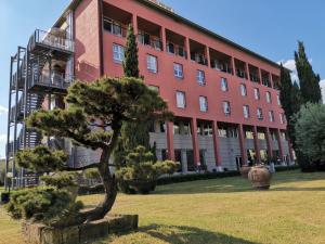 a pine tree in front of a building at Charme Hotel in Prato