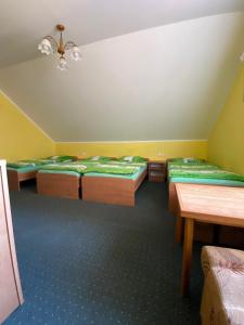 a room with four beds and a table at Willa Ewa in Jantar