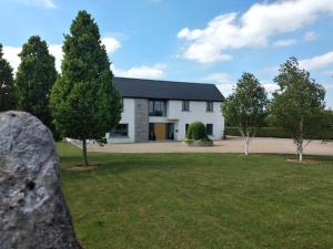 una casa bianca con alberi nel cortile di Brona Dempsey a Birr