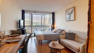 a living room with a bed and a couch at LOFT B64 in Les Angles
