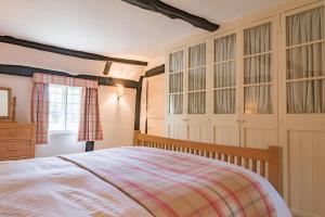 a bedroom with a bed and a dresser and a window at Walnut Tree Cottage by Bloom Stays in Faversham