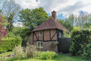 een oud huis met een poort in een tuin bij Walnut Tree Cottage by Bloom Stays in Faversham