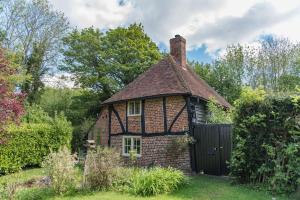 ein altes Haus mit einem Tor im Garten in der Unterkunft Walnut Tree Cottage by Bloom Stays in Faversham