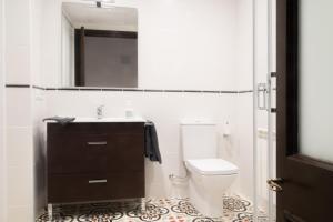 un bagno con un water, un lavandino e uno specchio di PLAÇA MAJOR 17 2n 1a a Banyoles Altre 22 foto