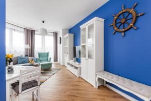 グディニャにあるGoodHome - Sea Towers Apartmentの青い壁と船輪の壁が特徴の子供部屋