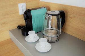 a blender sitting on top of a counter with two cups at Apartmán Nad Arénou NMNM in Nové Město na Moravě