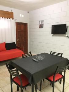 sala de estar con mesa con sillas y TV en Casa Nuova Depto DOS y TRES en Villa María