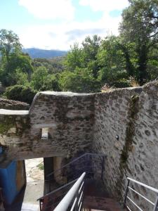 eine alte Steinmauer mit einer Bank und Bäumen in der Unterkunft El Patio Chico in Los Loros