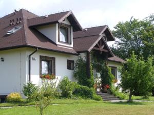 Biały dom z brązowym dachem w obiekcie Dworek Lachowicze w mieście Grzegorzewice