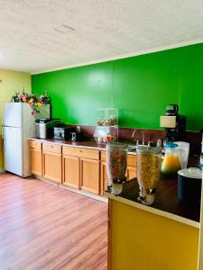 a kitchen with green walls and a counter with food at Holiday Lodge - Greensboro/Lake Oconee in Turnwold