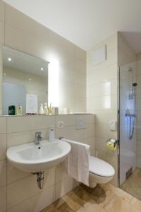 bagno con lavandino, servizi igienici e specchio di Wohntel - wohnen wie im Hotel a Sevelen
