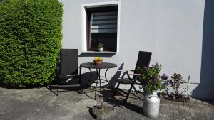 d'une terrasse avec une table, des chaises et une fenêtre. dans l'établissement Ferienwohnung Putbus, à Putbus