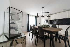 a dining room with a table and chairs and a kitchen at Voyageur sans bagage in Paris