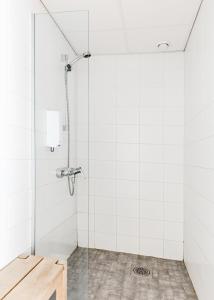 ein Bad mit einer Dusche und weißen Fliesen in der Unterkunft Sky Hostel Helsinki in Helsinki