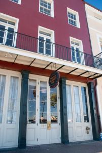 um edifício vermelho com uma varanda em cima em French Market Inn em Nova Orleans