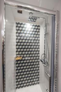 ein Bad mit einer Dusche mit einer blau-weißen Wand in der Unterkunft Magnum in Paris