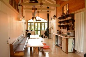 a kitchen with a table and benches in a room at Alexanderhaus, Pension und Restaurant in Mellensee