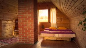 Rõuge的住宿－Grande Tiidu Sauna House，木制客房的一张床位,设有窗户
