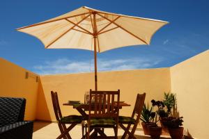 un tavolo e sedie con ombrellone su un patio di Few Steps to the Beach ad Alvor
