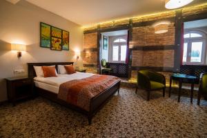 um quarto de hotel com uma cama, uma mesa e cadeiras em Hotel Starka em Opole