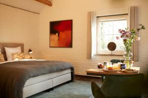 Het Knechthuys في بارلو: غرفة نوم بسرير وطاولة ونافذة
