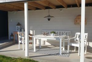 a white table and chairs on a patio at Irenegarden - Panorama apartment in Lauvstad