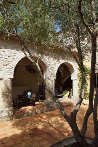 ein Steinhaus mit zwei Bögen im Hof in der Unterkunft Chambres d´Hôtes Prieuré d'Orniols in Goudargues