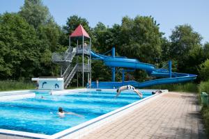 a group of people in a swimming pool with a water slide at Chalet Emlidanasy in Earnewâld