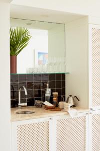 uma cozinha com um lavatório e um espelho em Palm Heights em George Town