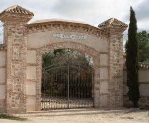 una entrada a un edificio con puerta de hierro en Casas rurales Puente Romano en Sonseca