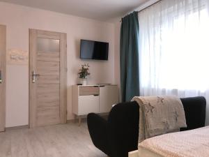 1 dormitorio con 1 cama, TV y puerta en Danusia en Władysławowo