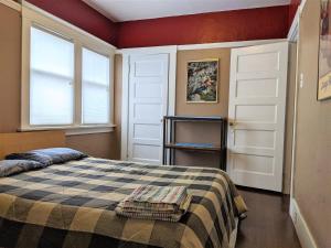 a bedroom with a bed and two windows at Relax in unpretentious peaceful and authentic house with public transportation cafes and U of Berkeley close by in Albany
